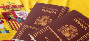 Documentos sobre nacionalidad española superpuestos a una bandera con texto «Solicitud de nacionalidad por carta de nat…