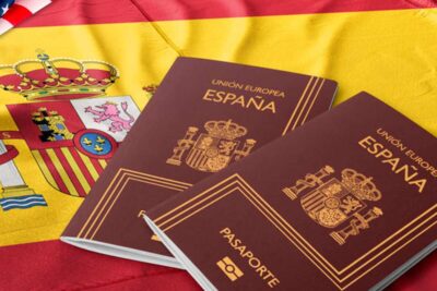 Documentos sobre nacionalidad española superpuestos a una bandera con texto «Solicitud de nacionalidad por carta de nat…
